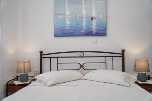 łóżko z dwoma lampami i obrazem na ścianie w obiekcie Moutsouna Beach w mieście Moutsoúna