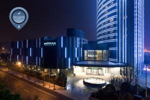 un grande edificio blu con un edificio di notte di Pullman Shanghai Xuhui a Shanghai