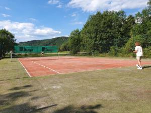2 personnes jouant au tennis sur un court dans l'établissement Sabine’s Gästehaus, à Übereisenbach