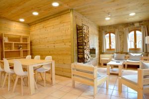 comedor con paredes de madera, mesa y sillas en El Jou Nature en Sant Corneli de Cercs 