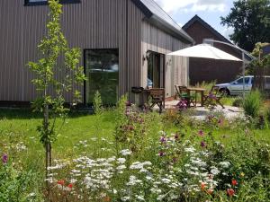 een tuin met bloemen voor een huis bij Haus am See in Rieste