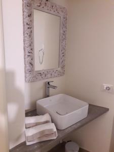 a bathroom with a white sink and a mirror at Al biancospino- Camere- Ristorante in Bossolasco