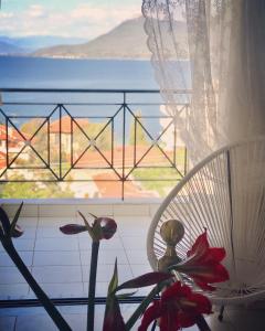 a window with a chair and a view of the ocean at Sagini Boutique Hotel in Loutra Edipsou
