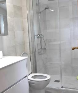 a bathroom with a toilet and a glass shower at Casa Azul in Santillana del Mar