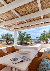 - une table et des chaises blanches avec vue sur l'océan dans l'établissement Casita Del Puerto Formentera Passport, à La Savina