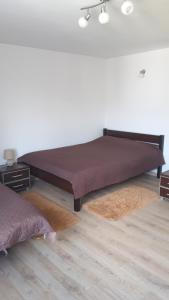 Ranczo Kaletnik في Kaletnik: سرير كبير في غرفة بها سجادتين
