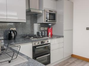 a kitchen with white cabinets and a stove top oven at Edmonton in Dumfries