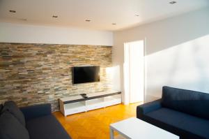 sala de estar con TV en una pared de ladrillo en Apartament Sen, en Łódź