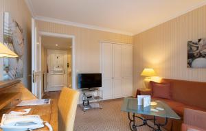a living room with a couch and a table at Strandhotel Sylt Westerland in Westerland