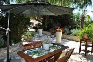 un patio con sombrilla, mesa y sillas en Apartment Pino, en Bale