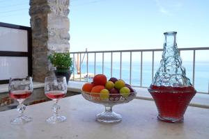 a table with two glasses of wine and a bowl of fruit at Moutsouna Beach in Moutsoúna