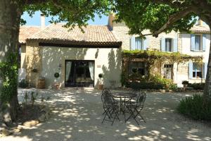 a table and chairs in front of a house at Le Mas Terre des Anges in Sarrians