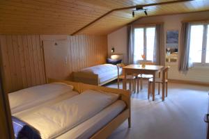 una camera con due letti e un tavolo e una sala da pranzo di First Lodge a Grindelwald