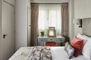 a bedroom with a bed and a desk with a mirror at Arlington House Apartments in London