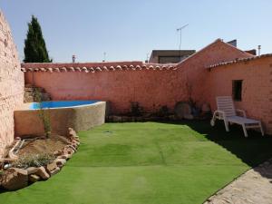 einen kleinen Garten mit Pool und Stuhl in der Unterkunft Casa Rural La Alfarera in Corral de Calatrava