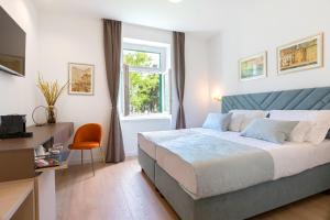 een slaapkamer met een bed, een bureau en een raam bij Green Park Luxury Rooms in Split