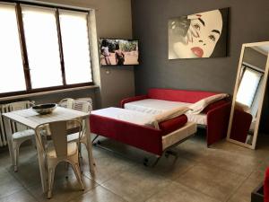 a room with a bed and a table and window at HappyHome Appartamento 4 posti letto Rivarolo Canavese in Rivarolo Canavese