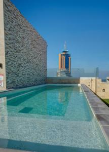 une piscine avec un bâtiment en arrière-plan dans l'établissement Allegro Hotel, à San Ġiljan