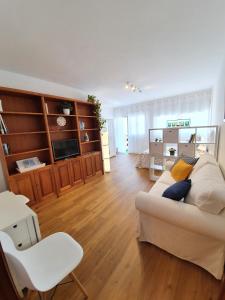 a living room with a white couch and a television at La Casita del Reloj in Santa Cruz de la Palma