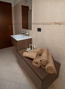 uma casa de banho com toalhas sentadas num banco ao lado de um lavatório em A casa di Sofy em Corropoli