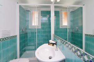 a blue tiled bathroom with a sink and a shower at RomeAsYouLike - Colosseo Experience 23 in Rome +15 photos