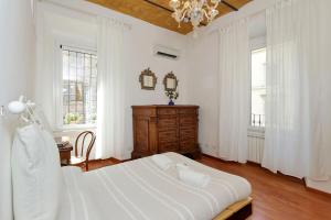 a white bedroom with a large bed and windows at RomeAsYouLike - Colosseo Experience 23 in Rome