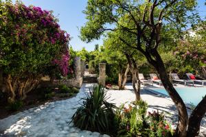 a garden with flowers and a swimming pool at Muazzo Historic Residence, a modernized gem, By ThinkVilla in Pigi