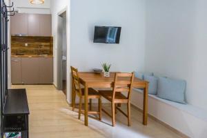 een eetkamer met een houten tafel en stoelen bij Cloud 5 Apartment in Kalamata