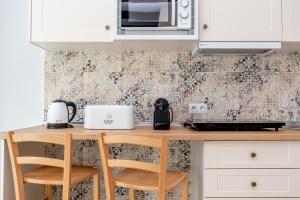 a kitchen counter with two stools and a microwave at Casa Del Patio - Boutique Apartments in Estepona