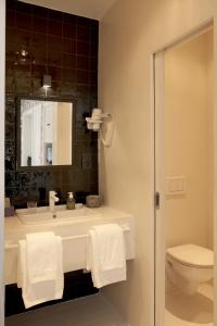 a bathroom with a sink and a toilet and a mirror at La Maison Haute guesthouse in Brussels