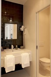 La salle de bains est pourvue d'un lavabo, de toilettes et d'un miroir. dans l'établissement La Maison Haute guesthouse, à Bruxelles
