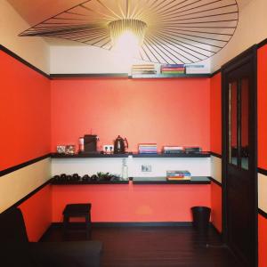 a room with an orange wall with a counter at La Maison Haute guesthouse in Brussels