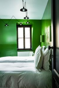 a green bedroom with a white bed and a window at La Maison Haute guesthouse in Brussels