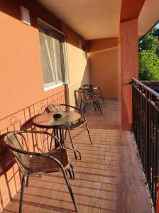 two tables and chairs on the balcony of a building at SergillioHouse in Chişcău