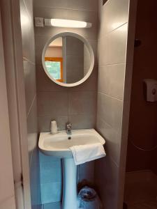 La salle de bains est pourvue d'un lavabo et d'un miroir. dans l'établissement Premiere Classe Annecy Cran-Gevrier, à Annecy