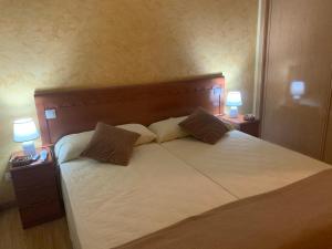 La Concha的住宿－posada carral cabarceno，一间卧室配有一张大床和两盏灯
