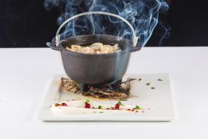 a pot of food on a plate with smoke at City Hotel Sova in Nizhny Novgorod