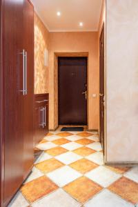 a hallway with a door and a checkered floor at Apartment Triokhsviatytelskaya Street 3 in Kyiv