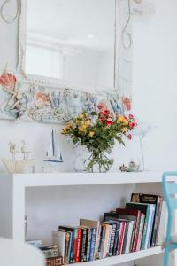 un estante con un jarrón de flores y libros en Hotel Opera en Lárnaca