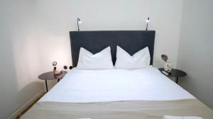a bedroom with a bed with white sheets and pillows at House in House at the Heart of Exarchia, extremely central in Athens