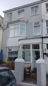 a white house with a sign in front of it at Brampton Guest House in Paignton