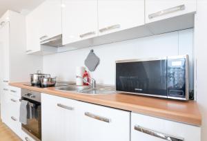 a kitchen with a sink and a microwave at Sunny Penthouse with Terrace. DG7 in Vienna