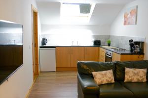 a living room with a couch and a kitchen at Millburn Apartments in Inverness