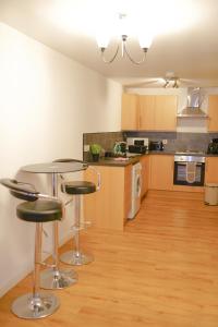 a kitchen with a table and two stools at Millburn Apartments in Inverness