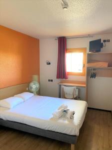 
A bed or beds in a room at Premiere Classe Annecy Cran-Gevrier
