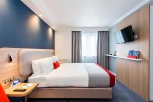 a hotel room with a bed and a tv at Holiday Inn Express Strathclyde Park M74, Jct 5 by IHG in Motherwell +28 photos