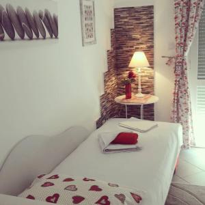 ein Schlafzimmer mit einem Bett mit einem Tisch und einer Lampe in der Unterkunft Apartmani Dačo in Sveti Stefan