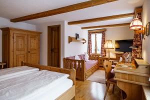 a bedroom with a bed and a desk at Alpenblick Hotel & Restaurant Wilderswil by Interlaken in Wilderswil