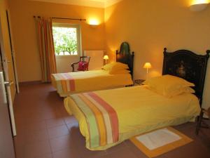 um quarto de hotel com duas camas e uma janela em La Closerie em Saint-Nizier-le-Bouchoux