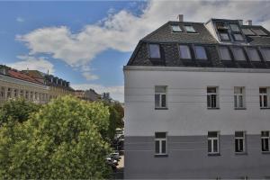 a white building with a roof on top of it at Sunny Penthouse with Terrace. DG7 in Vienna